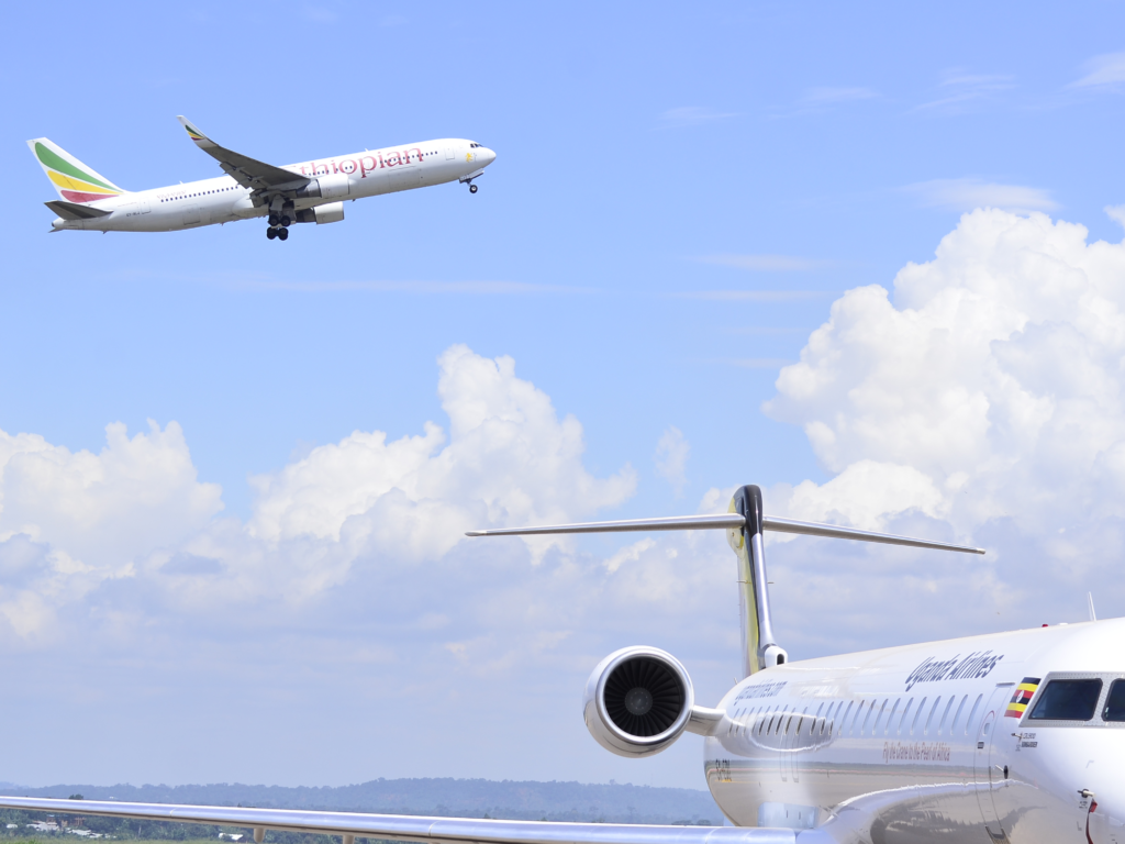 An Ethiopian Plane flying over one of the Bombardier CRJ 900 planes
