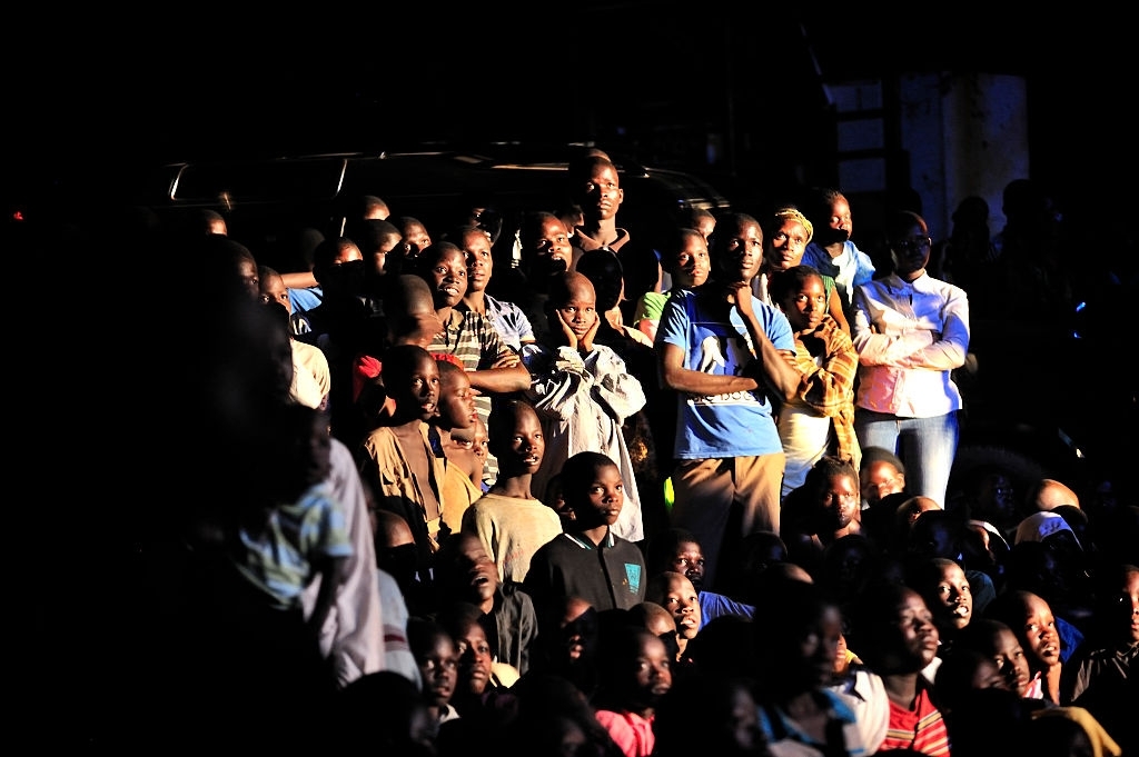 People watching a movie on a mobile cinema in Uganda